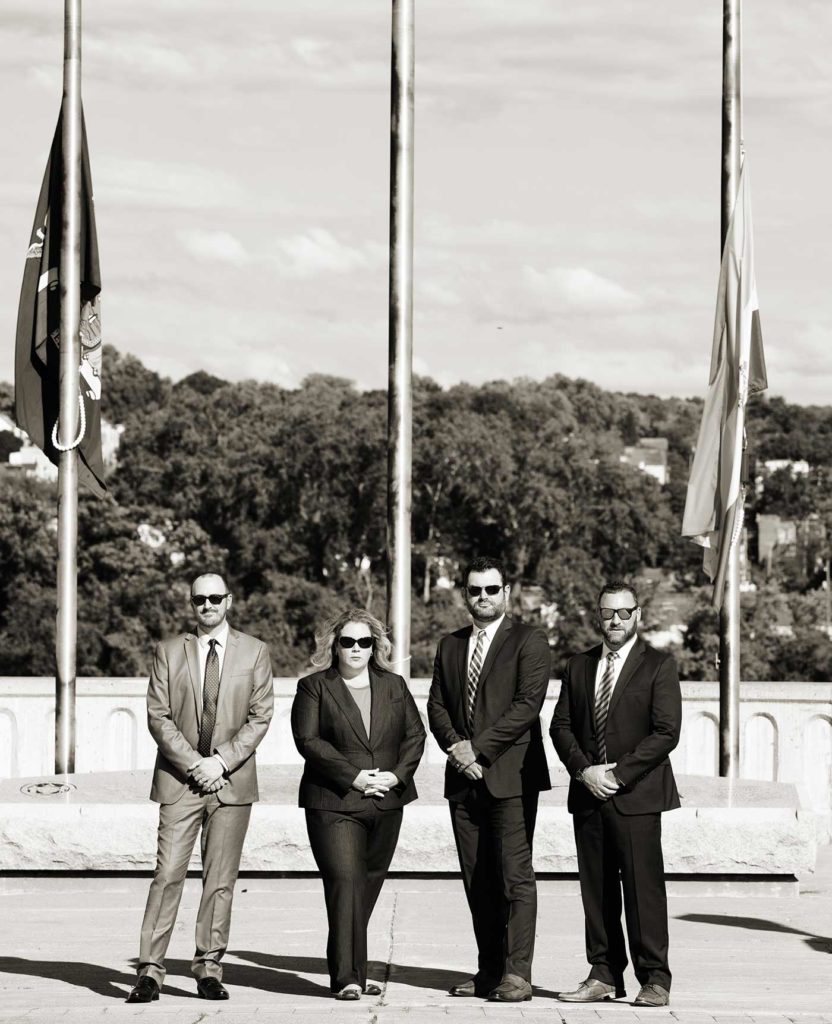 MCLC partners in front of flagpoles